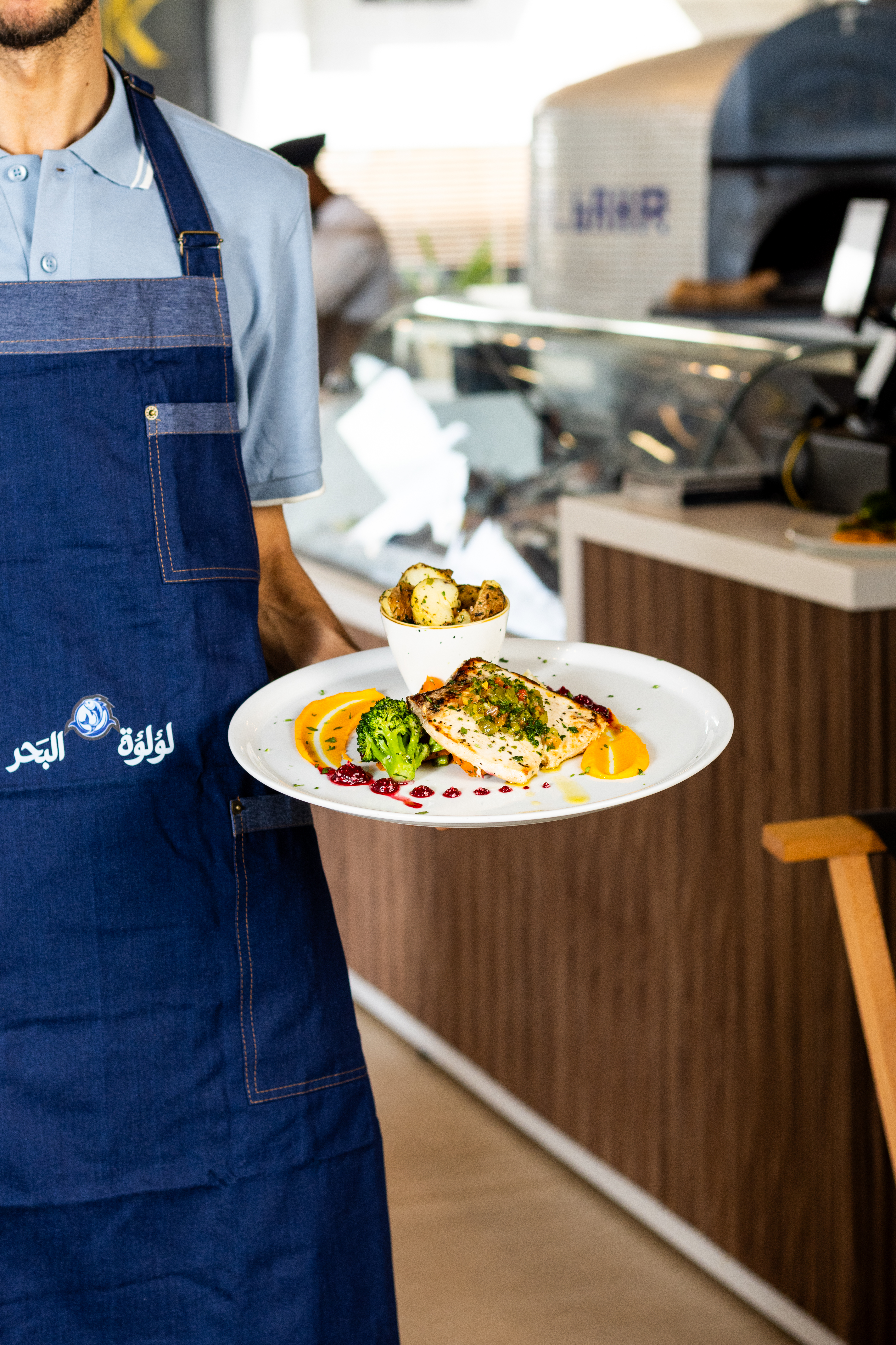 Un serveur en train de servir un plat de filet de poisson dans un restaurant à Casablanca.